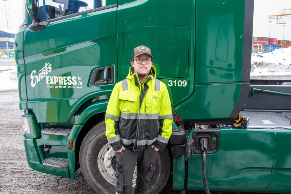 Chauffören Alexander Byggnings framför den eldrivna lastbilen, som laddas i Gävle hamn.