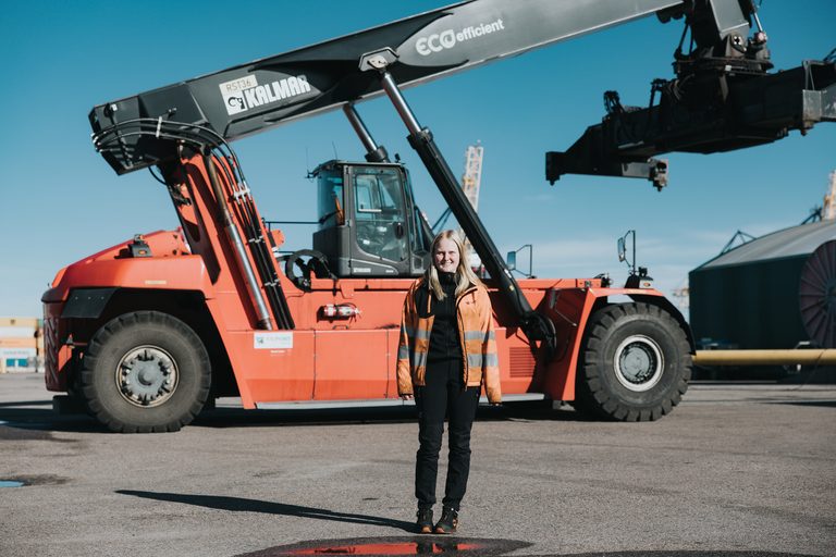 Amelia framför en containertruck.